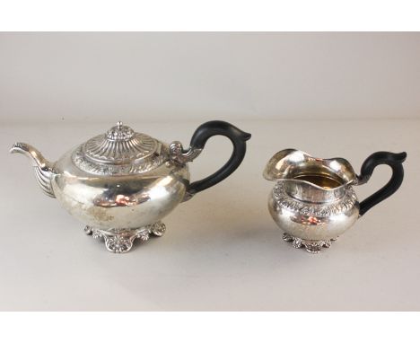 A German  silver teapot and matching milk jug, circular form with dome lid and embossed foliate border, spread eagle mark wit