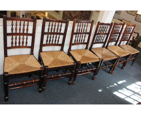 A matched set of six Lancashire style rush seat dining chairs, each with bobbin turned back, on turned front legs and pad fee