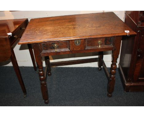 An 18th century oak side table with rectangular panelled frieze drawer with two pear shape drop handles, on bobbin turned leg