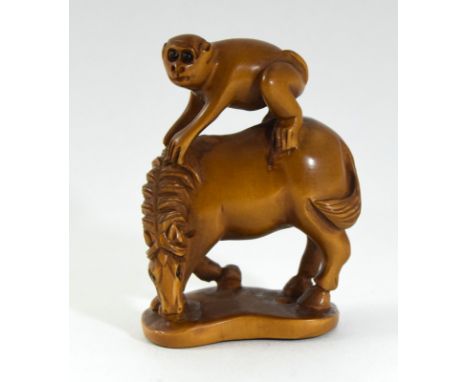 Carved Japanese netsuke depicting a monkey on a horses back signed to the base