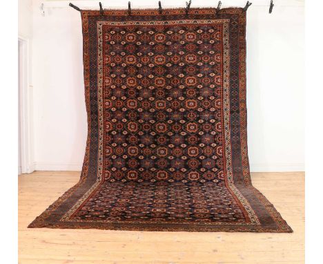 A Kurdish Mina Khani design carpet,with floral motifs, to a navy ground, and a red and blue geometric border,380 x 213cmCondi