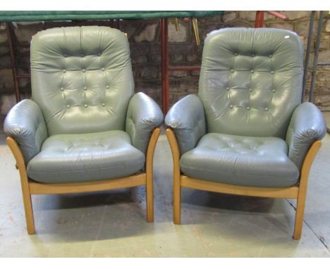 An Ercol three piece lounge suite comprising three seat sofa and pair of matching armchairs with light wood frames and button