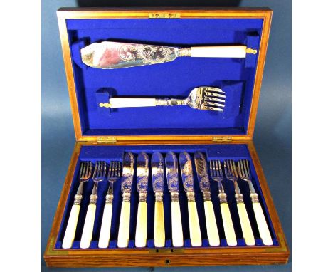 An antique oak canteen of silver plated fish knives and forks for six settings complete with serving knife and fork, all with
