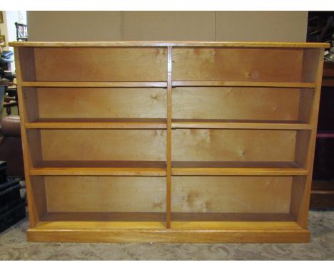 A light oak two divisional floorstanding open bookcase with adjustable shelves set on a moulded plinth 156 cm wide x 22  cm d