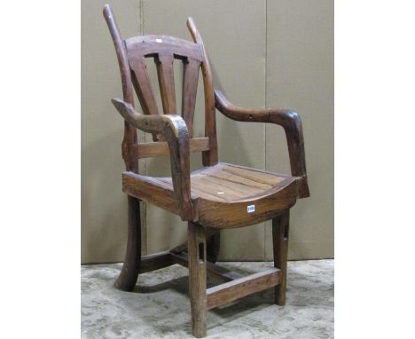 A vintage rustic wooden open armchair with dished seat 
