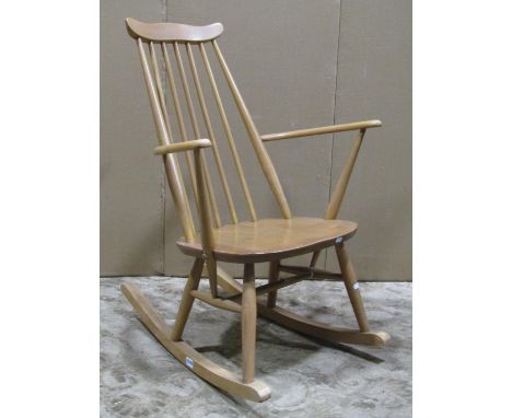 A vintage light elm and beechwood stick back rocking chair 