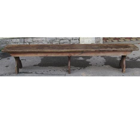 A vintage stained pine low bench with plank seat raised on three chamfered supports, 213 cm long (7ft) x 31 cm wide x 42 cm h