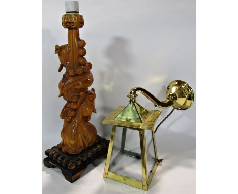 A brass  wall hung lantern with four glass shades, 22cm and a Far Eastern design carved wooden table lamp entwined with fish.