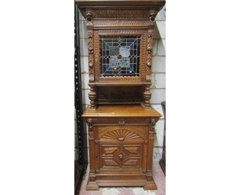 A 19th century oak pier cabinet, the lower section enclosed by a panelled door with lion mask and other details, together wit