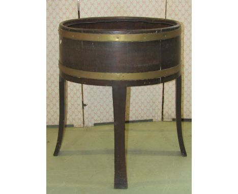 A coopered oak and brass banded planter of oval form, raised on shaped supports, 58 cm x 45 cm x 70 cm high 