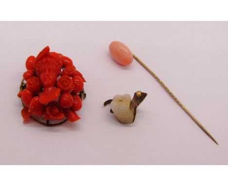 19th century carved coral brooch depicting a maiden amidst flowers, 11.4g, together with a coral stick pin, 2.7g and a gold m