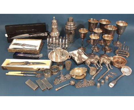 A miscellaneous collection of silver plated items including a cocktail shaker, toast rack, wine goblets, chamber stick, loose