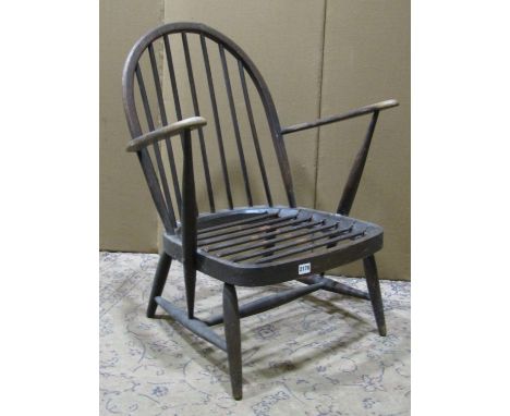 A vintage Ercol dark stained beechwood hoop and stick back open armchair with sprung seat (af) 