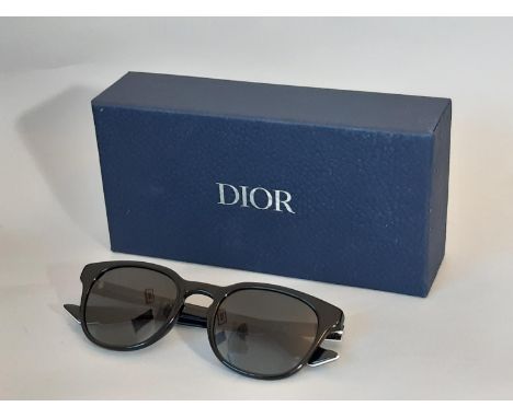 A pair of mens sunglasses by Christian Dior Homme, appear unused, with envelope style case in black leather, soft cloth case,