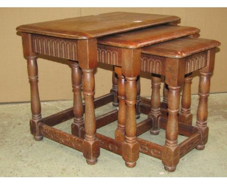 A nest of three oak graduated occasional tables in the old English style, outer table 61 cm wide x 38 cm deep together with a