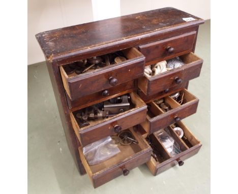 Wooden twelve drawer chest enclosing a quantity of clock fittings and tools, to include longcase pulleys, case fittings, lath