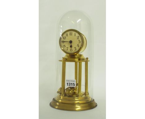 Torsion thirty day mantel clock, the 2.5" circular dial within a drumhead surround and upon a circular plinth supported by fi