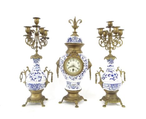 Delft type pottery and gilt metal single train mantel clock garniture, the 3" circular dial set within an urn case surmounted