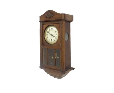 Oak torsion cased wall clock, the large movement with front wind, the 5.25" silvered dial over a three-part pendulum window, 