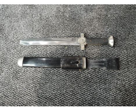 A German WW2 Red Cross Officer's Dress Dagger with Saw back edge and flat tip, blade marked Ges Geschutzt, black metal scabba