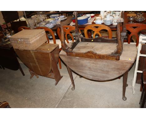 An oak drop leaf table; a mahogany drop leaf table; a stool frame; and a wicker picnic hamper 