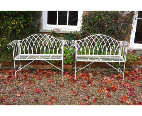  A pair of white painted metal garden seats,   loosely in the George III style, late 20th century, with arched backrests and 