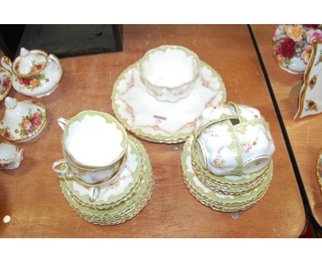 A Victorian Crown Staffordshire part tea service pattern No. 2253 having a floral decoration within green scrolling borders r