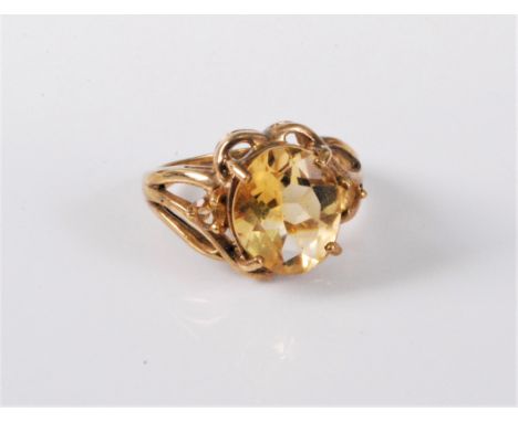 A 9ct gold citrine ring, the oval citrine, claw mounted with tapered tri-furcated shoulders and plain band, hallmarked Birmin