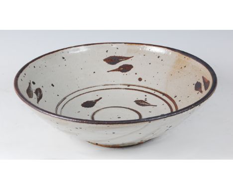 A large studio pottery glazed circular table bowl, in the manner of Bernard Leach, leaf decorated with concentric banding, un