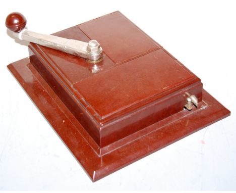 A French Art Deco bakelite wall mounted cigarette dispenser, having chromed metal dispensing arm, of stepped chamfered form, 