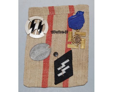 A small collection of post-WWII German effects, to include SS 12 year service medal, cloth badge, stick pin, armband etc