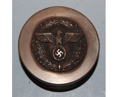 A German snuff-box, the removable lid relief decorated with eagle and swastika emblem within wreath, dia. 7cm