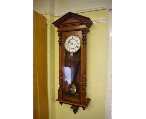 A walnut Vienna style wall clock, with enamel dial, 118cm high, with pendulum and weights. 