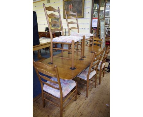 An Ercol 'Golden Dawn' dining table and chairs, comprising a drawleaf table, 203cm extended; and eight ladder back chairs. 