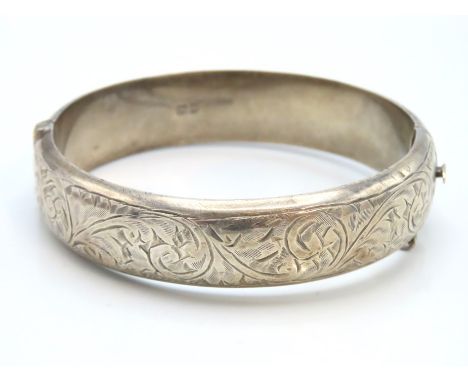 A 1951 Chester silver bangle with chased decor, 62mm x 55mm internally, 24g