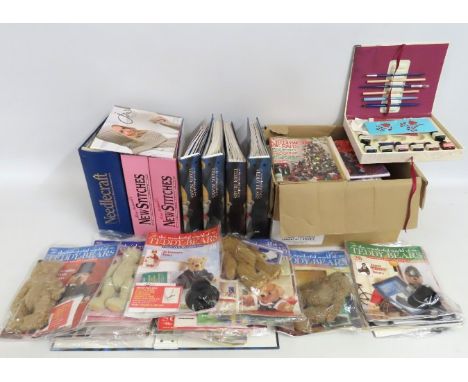 A quantity of needlecraft, pattern magazines, a calligraphy set & De Agostini teddy bear clothing kits