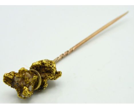 An antique yellow metal tie pin, tests electronically as at least 9ct gold, set with natural gold nugget with stone, gold tes