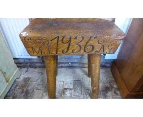 A compact rustic hardwood Butchers block on ashwood legs, carved with the date 1936 - Height 74cm x 66cm x 37cm