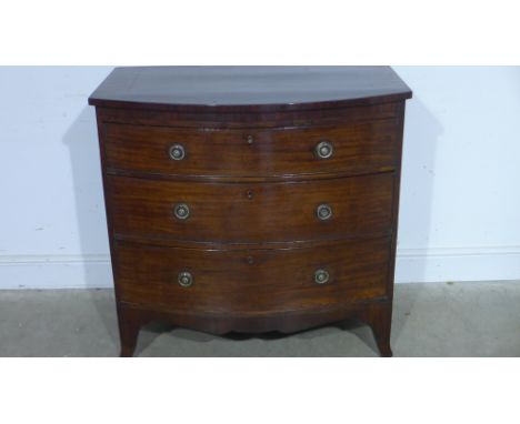 An early 19th century mahogany chest of three long graduated drawers with brass ring handles, shaped apron and raised on brac