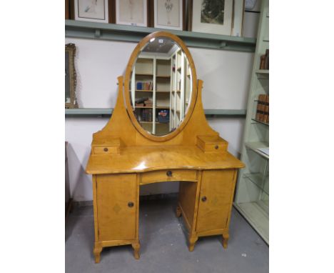 A Scandinavian fruitwood dressing chest, oval mirror over two trinket drawers above two doors opening to reveal drawers, rais