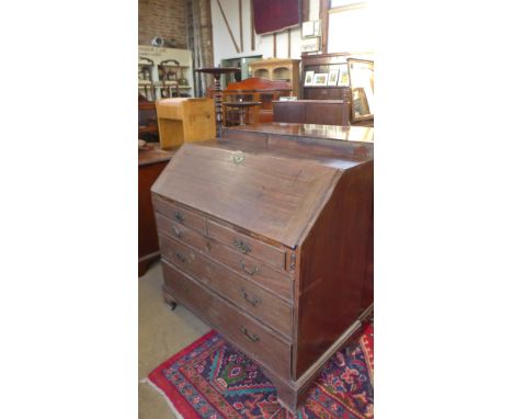 A Georgian mahogany bureau with a fitted interior over two small and three long graduated drawers with brass drop handles and