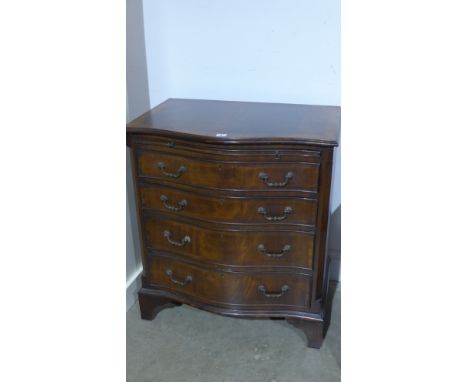 A Georgian style mahogany and crossbanded serpentine fronted chest of four graduated drawers with brushing slide, brass drop 