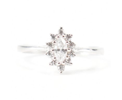 A hallmarked 9ct white gold and CZ halo ring. The ring set with a central marquise cut CZ framed by round brilliant cut CZ to