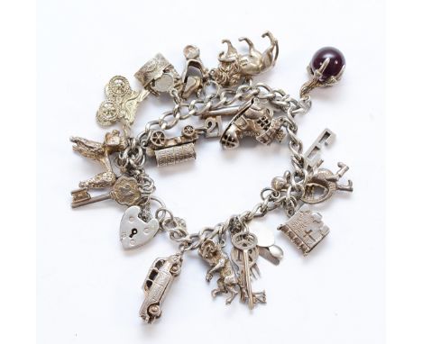 A silver charm bracelet, includes a Georg Jensen padlock clasp and fifteen other silver charms, 82g