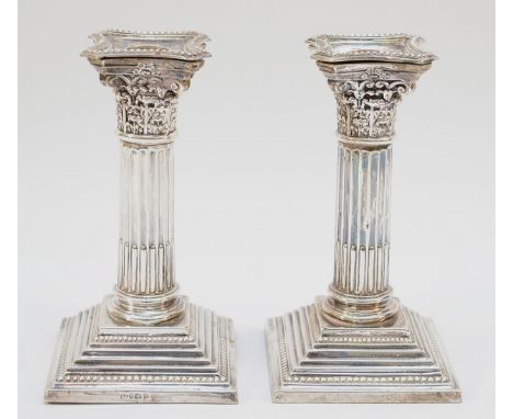 A pair of Victorian silver Corinthian column candlesticks, Birmingham 1901, with detachable sconces, loaded, 16cm. In overall