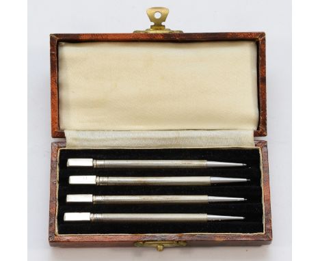 A set of four sterling silver twist action propelling pencils, 9cm, cased.