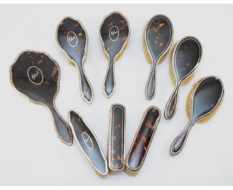 A silver and tortoise shell dressing table mirror, Birmingham 1914, with two matching hair brushes and a matching clothes bru