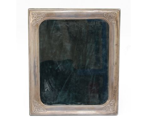 A silver photograph frame, Dublin 1997, with embossed Celtic decoration to the corners, 30x25cm.