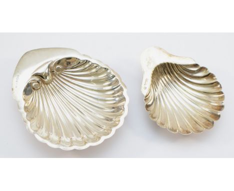 A silver shell shaped trinket dish raised on three ball feet, Birmingham 1915, together with another silver shell shaped dish
