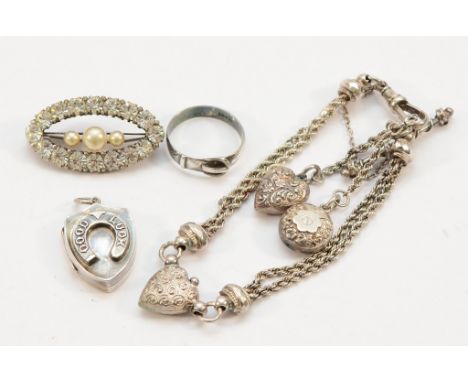 A Victorian silver good luck locket, Birmingham 1886, 23mm, a silver buckle ring, P 1/2, a silver gemset brooch, 35mm, and a 